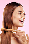 Beauty, comb and smile with hair of woman for health, salon and satisfaction in studio. Wellness, keratin and natural with girl model and self care for cosmetics, brush and shine on pink background