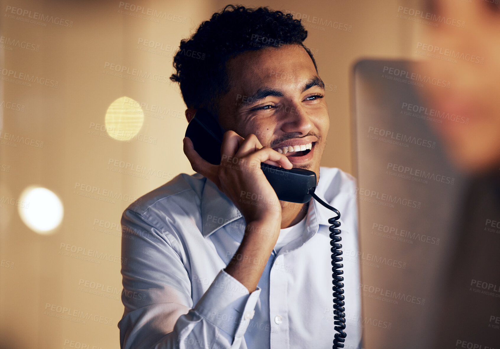 Buy stock photo Telephone, night and businessman on a phone call in the office talking while working on a computer. Discussion, communication and professional male employee speaking on a landline in the workplace.