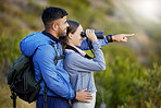 Binoculars, point and a couple bird watching in nature while hiking in the mountains together. Forest, nature or sightseeing with a man and woman looking at the view while bonding on a hike
