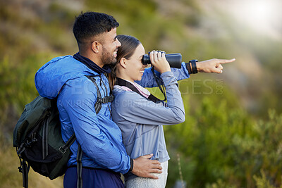 Buy stock photo Binoculars, point and a couple bird watching in nature while hiking in the mountains together. Forest, ecology or sightseeing with a man and woman looking at the view while bonding on a hike
