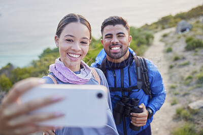 Buy stock photo Man, woman and hiking selfie with smile, love and happiness in nature for outdoor adventure on holiday. Young happy couple, blog and mountain for care, bonding and vacation with social media app