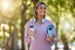 Fitness, woman and smile for yoga, spiritual wellness or healthy lifestyle in nature outdoors. Happy female yogi smiling with water bottle, mat and headphones for calm exercise or workout in the park