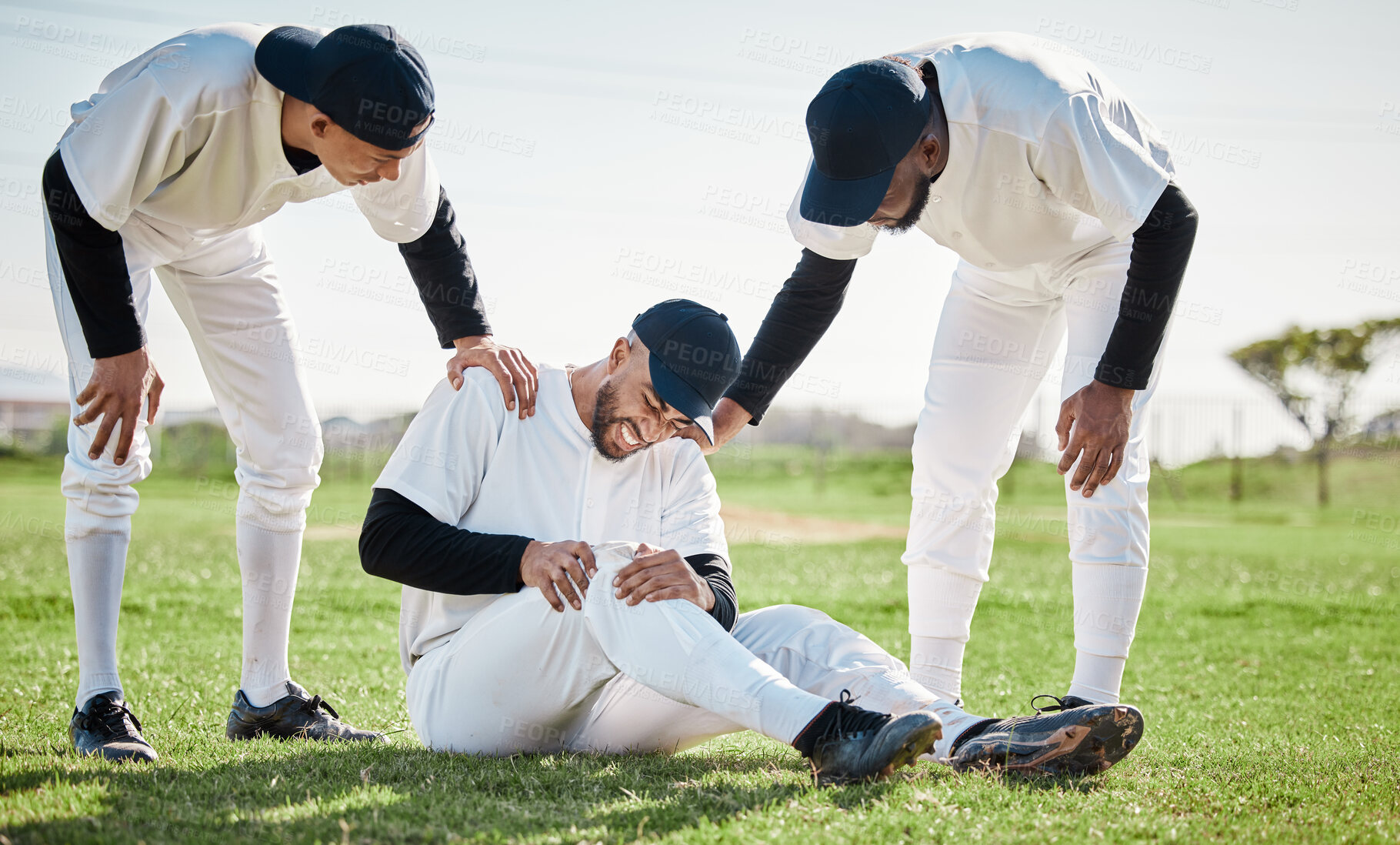 Buy stock photo Baseball, team help and man with injury on field after accident, fall or workout in match. Sports, training and male player with fibromyalgia, inflammation pain or broken knee with friends helping.