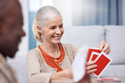 Buy stock photo Playing cards, game and a senior woman in a retirement home having fun while sitting in a living room. Card games, happy and gambling with senior friends in a house to play poker or relax together