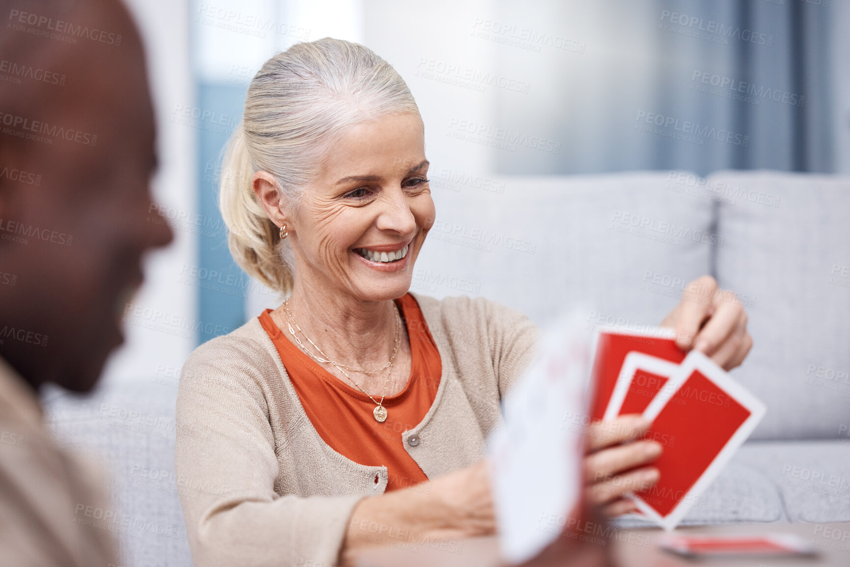 Buy stock photo Playing cards, game and a senior woman in a retirement home having fun while sitting in a living room. Card games, happy and gambling with senior friends in a house to play poker or relax together