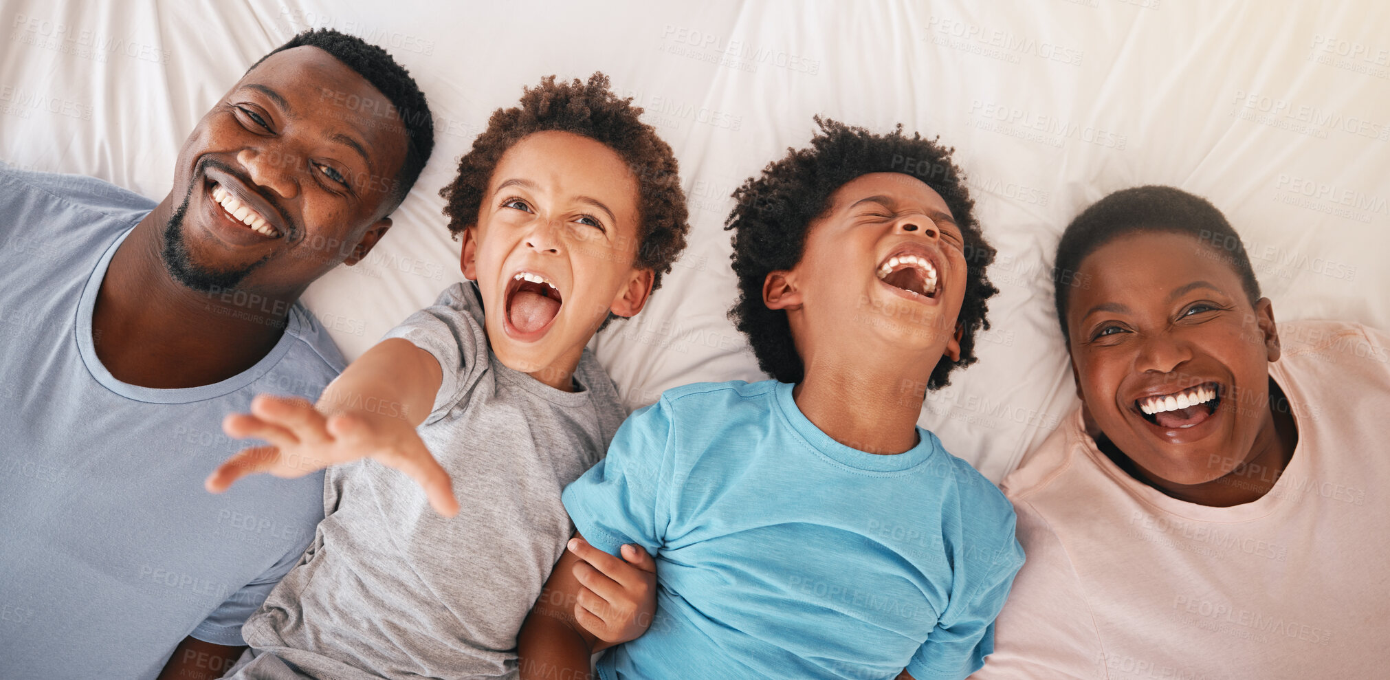 Buy stock photo Laugh, happy and relax with black family in bedroom for bonding, wake up and morning routine from top view. Smile, funny and cute with parents and children at home for calm, weekend and quality time 