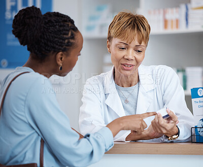 Buy stock photo Healthcare, label information and black woman with pharmacist at counter for advice on safe prescription drugs. Health, pharmaceutical info and patient consulting medical professional at pharmacy.