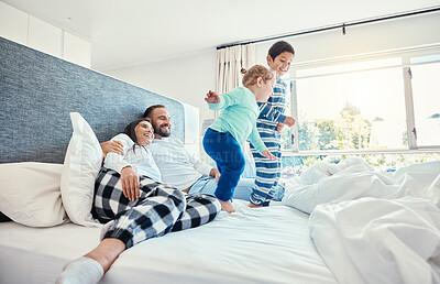 Buy stock photo Family, morning and kids jumping on a bed, playing while having fun in the bedroom of their parents. Happy, children or wake up with a brother and sister in a house feeling playful or excited