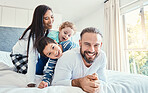 Family, portrait and laughing on bed in home, having fun and bonding together. Comic, love and care of happy father, mother and kids or boys playing, smile and enjoying quality time in house bedroom.