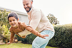 Carefree, flying and portrait of a father with a child in a garden for freedom, play and bonding. Happy, laughing and dad holding a boy kid to fly while playing in the backyard of a house together