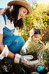 Family, kids or gardening with a mother and daughter planting plants in the backyard together. Nature, children or landscaping with a woman and female child working in the garden during spring