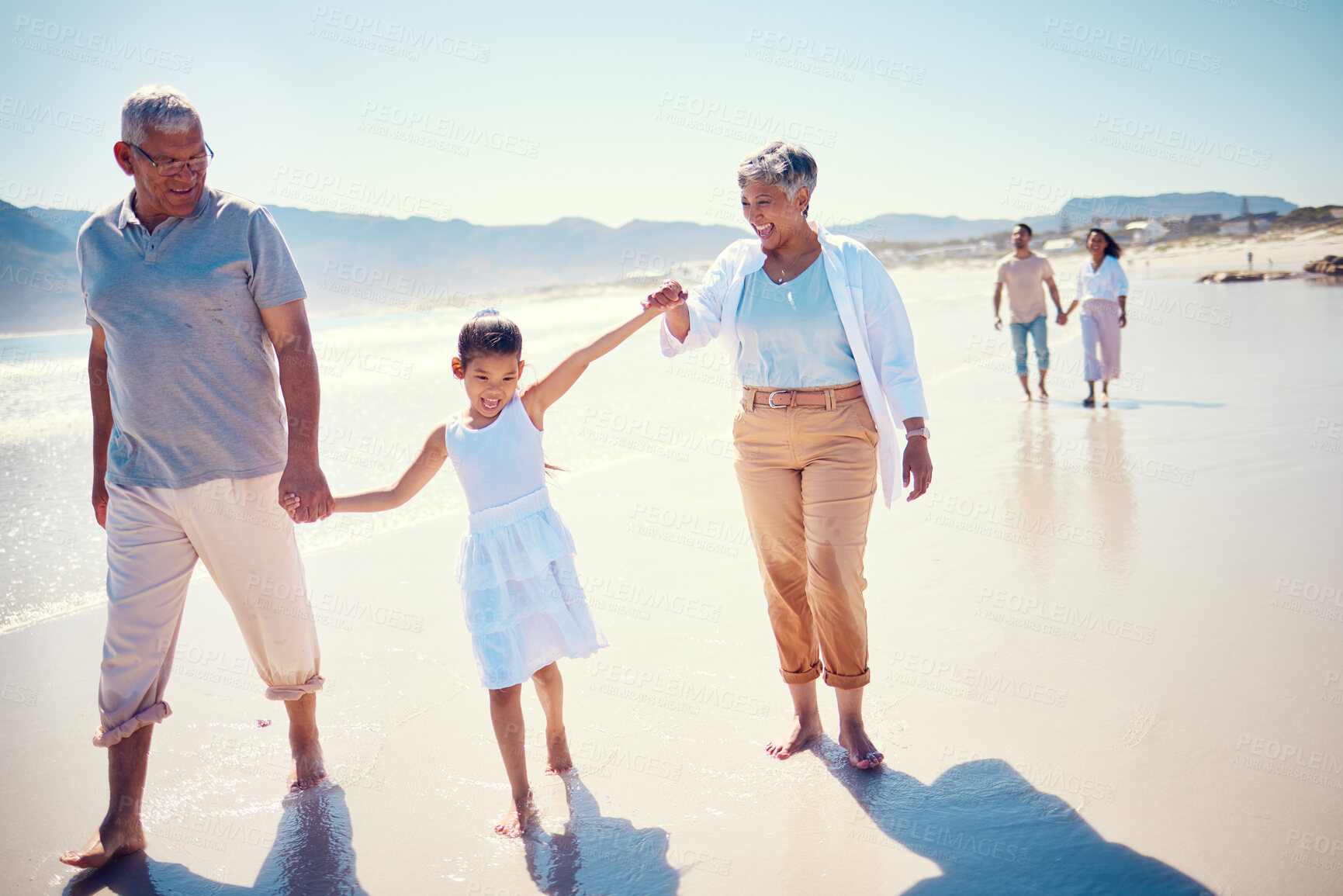Buy stock photo Relax, travel and holding hands with big family on beach for vacation, summer break and generations. Happiness, holiday and bonding with grandparents and children walking for love, rest and trip