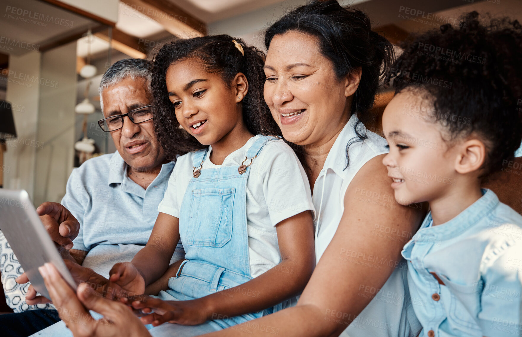 Buy stock photo Family, relax and girl with tablet in home living room for social media, video streaming or web browsing. Technology, smile or care of happy grandfather, grandma and children bonding with touchscreen