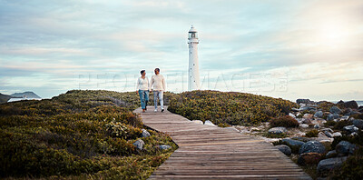 Buy stock photo Romance, love and a couple holding hands while walking on the beach with a lighthouse in the background. Nature, view or blue sky mockup with a man and woman taking a romantic walk outside together