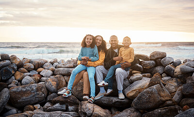 Buy stock photo Black family, parents and children in beach portrait with excited face, sitting and rocks with happiness. Black woman, man and kids by ocean with love hug, care and bonding on holiday by sunset sky