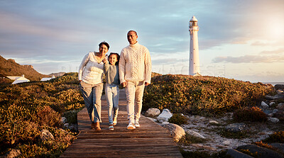 Buy stock photo Happy, beach and girl with grandparents on boardwalk for travel vacation, bonding or sunset. Lighthouse, summer break and commitment with child and senior couple walking for support, positive or care