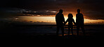 Beach, sunset and silhouette of a family holding hands while on a summer vacation or weekend trip. Adventure, love and shadow of people in nature by the ocean together while on seaside travel holiday