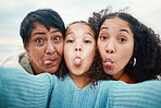 Funny, tongue out and portrait of a family selfie, silly and goofy at the beach in Bali. Comic, crazy and girl taking a photo with a mother and grandmother for a playful memory on holiday at the sea