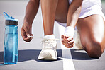 Woman, hands and tying shoe lace on tennis court getting ready for sports match, exercise or workout outdoors. Hand of sporty female tie shoes in preparation for sport training, game or activity