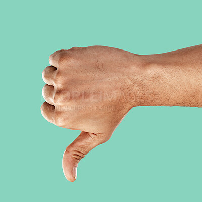 Buy stock photo Hand, thumbs down and negative emoji with a man in the studio on a green background for disagreement. Gesture, no and negativity with a male indoor to disagree, vote or voice his review and feedback
