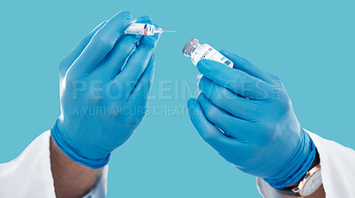 Buy stock photo Closeup, hands and needle for vaccine, healthcare and research with blue studio background. Zoom, gloves and liquid bottle with medical equipment, medicine and vial for cure, vaccination and results