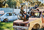 Paintball, car jump or male in shooting game playing with speed or fast action on fun battlefield. Military mission, jumping or man running with weapons gear for survival in an outdoor competition 