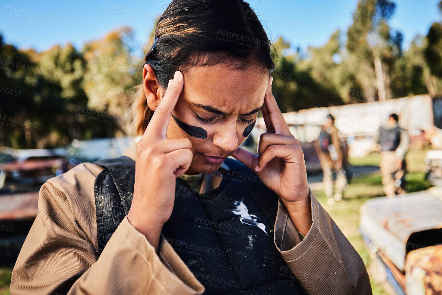 Buy stock photo Paintball, headache and woman on a outdoor gun range feeling an ache in the sun from combat. Female soldier, sports exercise and shooting safety game with a young person suffering in the sunshine