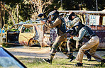 Team, paintball and army moving on the attack in extreme adrenaline sport, battle or war in the nature outdoors. Group of paintballers or soldiers walking or aiming down sights in teamwork engagement