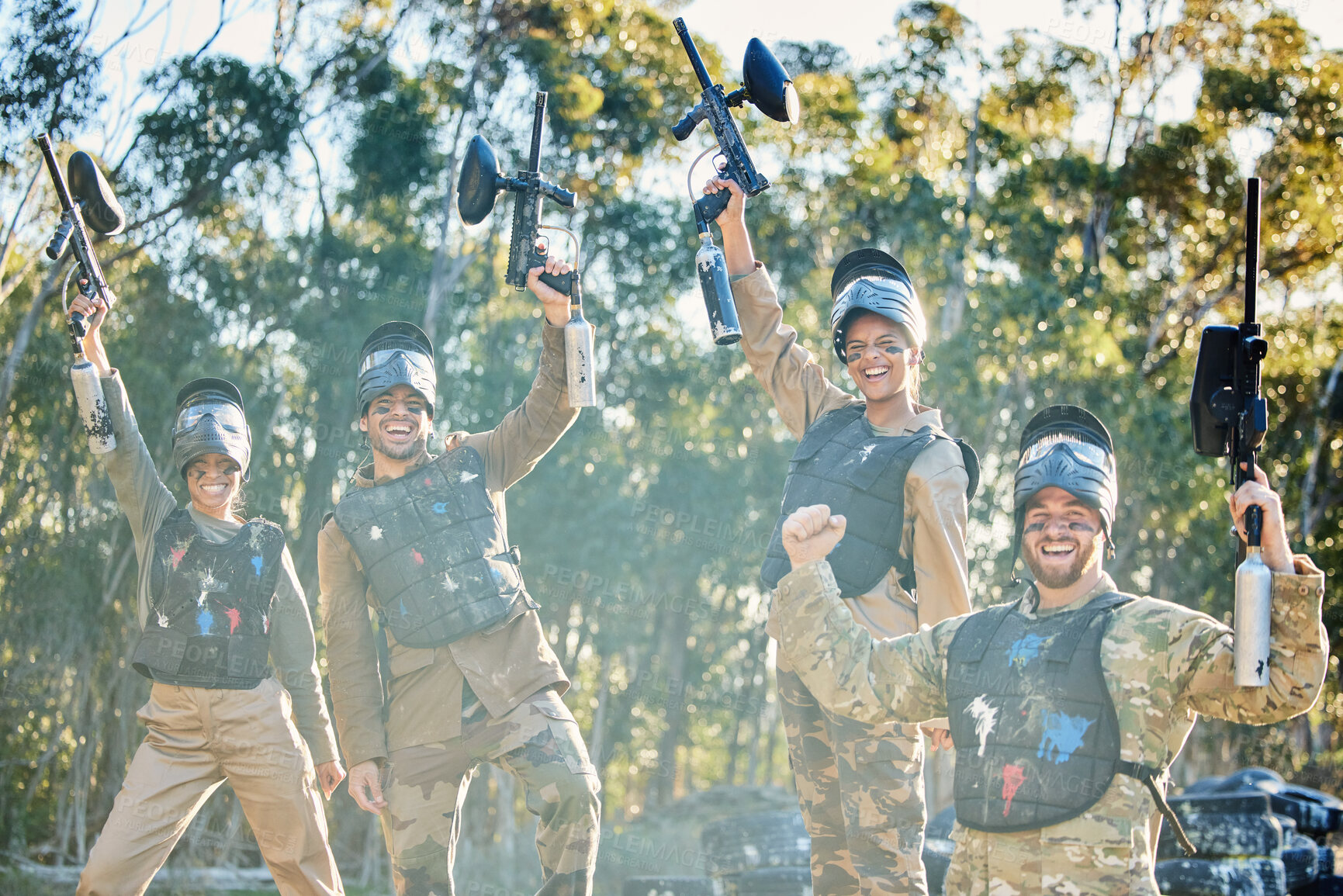 Buy stock photo Team, paintball and portrait in celebration for winning, victory or achievement on the battlefield together in nature. Group of people enjoying win, success or teamwork with guns in the air for sport