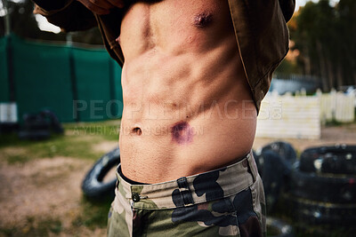 Buy stock photo Paintball, injury and man with wound on abdomen, military game and extreme sports, accident and injured soldier. Shooting accident, bruise of stomach and pain with camouflage and male on battlefield