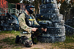 Paintball, gun and camouflage with a sports man on a battlefield for military or war training for the army. Fitness, team building and safety with a male athlete or soldier playing a game outdoor