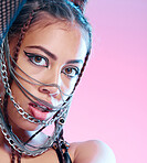 Chains, style and portrait of goth woman with unique fashion isolated against a studio pink background. Face, accessories and edgy female model metal jewelry on her head and cool makeup