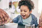 Excited, happy and child ready for breakfast cereal in the morning feeling hungry for cornflakes in a home or house. Kid, food and young boy in the kitchen smile due to meal sitting at table