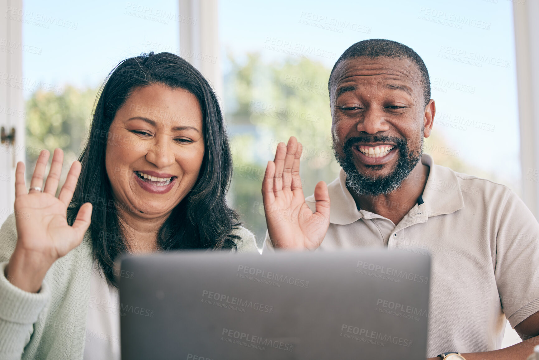 Buy stock photo Mature couple on video call for home networking, international conversation and talking to people online. Virtual communication, wave hello and happy biracial woman with her partner on laptop