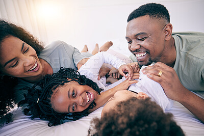 Buy stock photo Laugh, tickle and morning with black family in bedroom for wake up, bonding and affectionate. Weekend, smile and care with parents and children at home for playful, funny and free time together