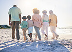 Family walk on the beach, holding hands and generations with travel and summer vacation, solidarity and love outdoor. Grandparents, parents and children on holiday, people together with back view