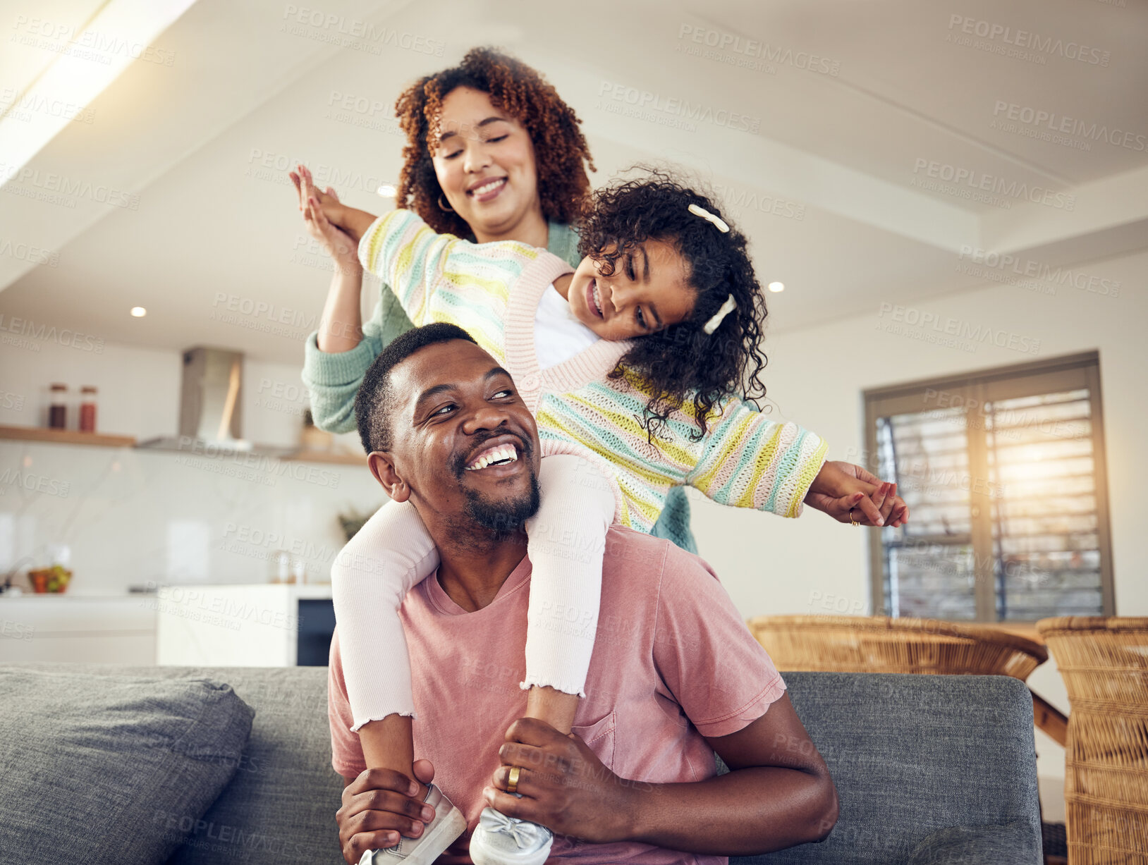 Buy stock photo Black family, father and daughter playing with mother on living room sofa together for fun bonding at home. Happy dad carrying child for piggyback ride with mom on lounge couch enjoying holiday break