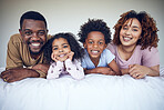 Black family, portrait and relax in bed, happy and smile while bonding in their home together. Face, children and parents waking up in bedroom, lying and resting, having fun and enjoying the weekend