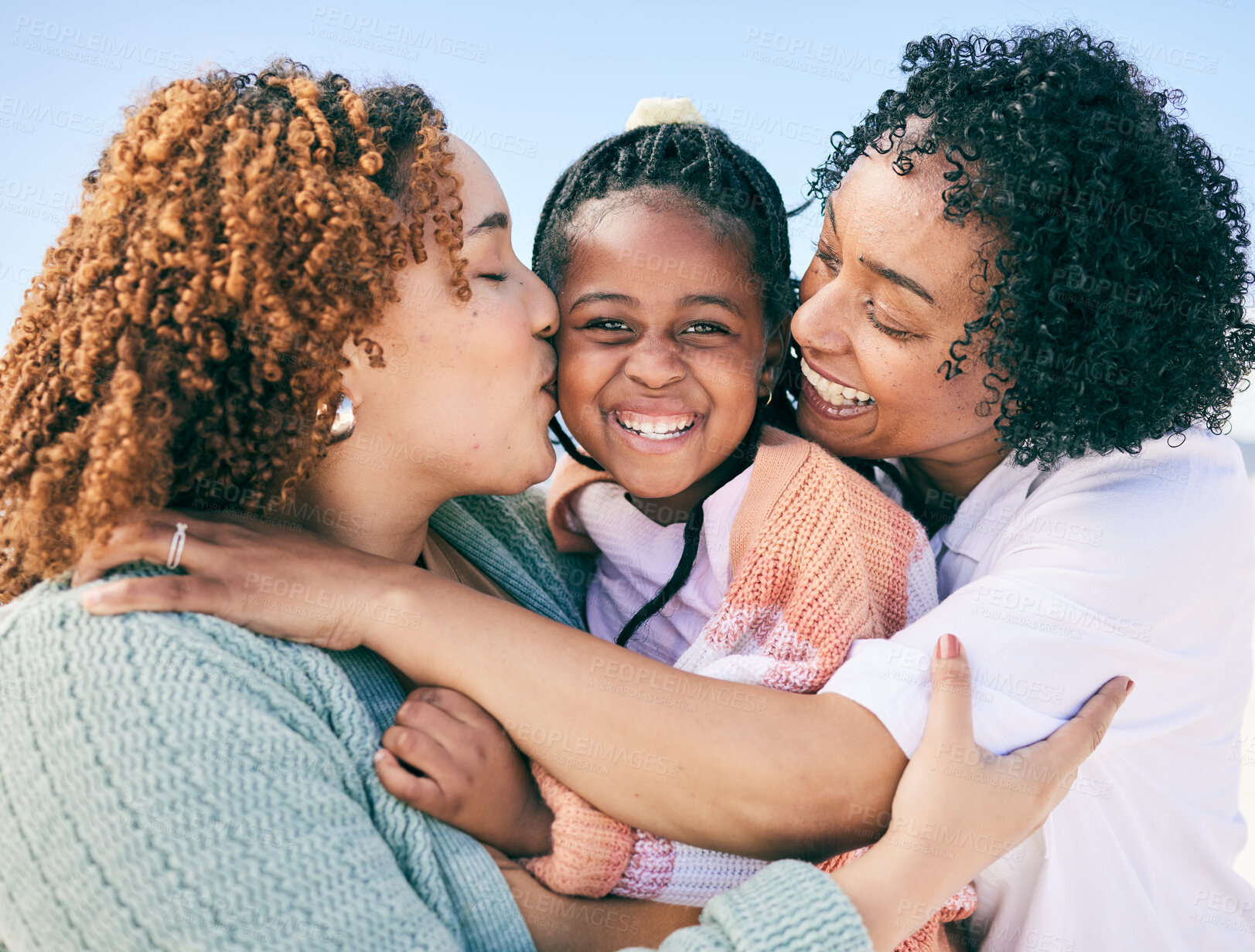 Buy stock photo Love, lesbian and couple with girl, quality time and kiss with smile, cheerful and happiness. Family, women and parents with daughter, female child and adoption with affection, hug or embrace outdoor