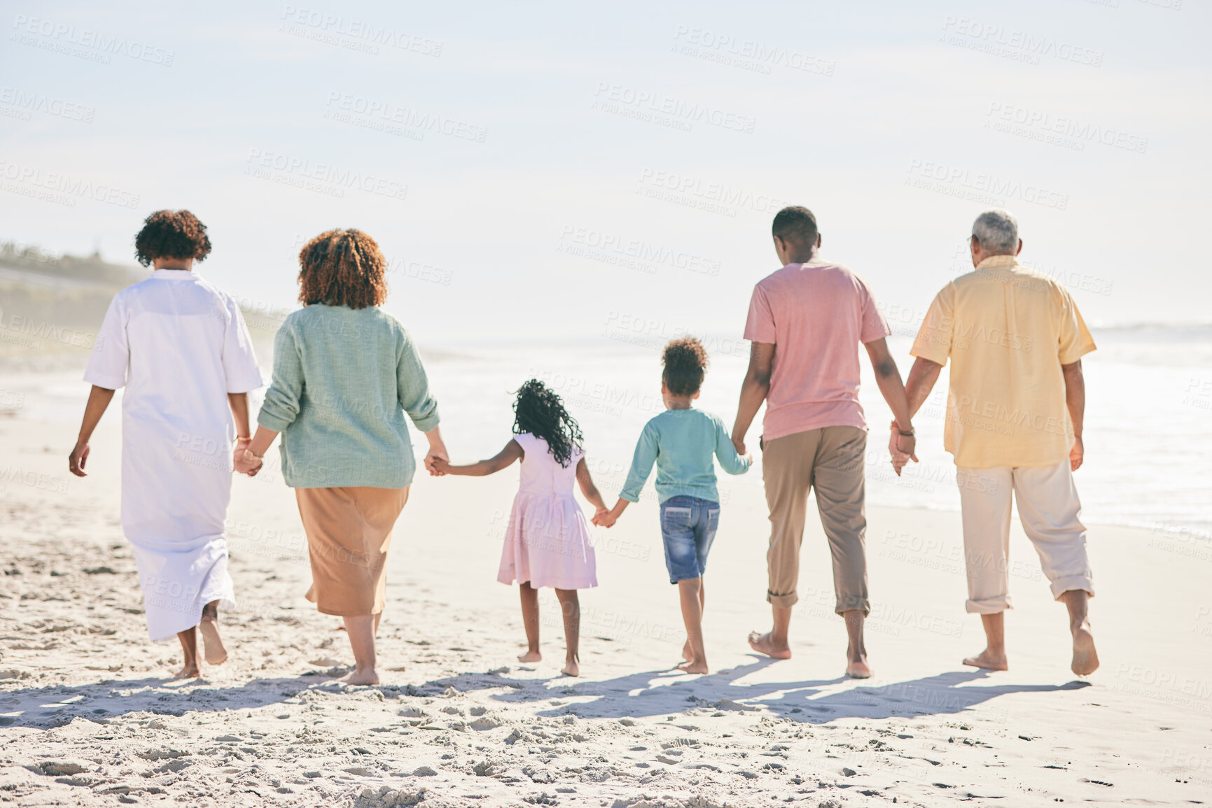 Buy stock photo Family at beach, holding hands and generations walk on sand, people outdoor with grandparents, parents and kids. Together, support and trust, travel to Bali with love, care and bond with back view 