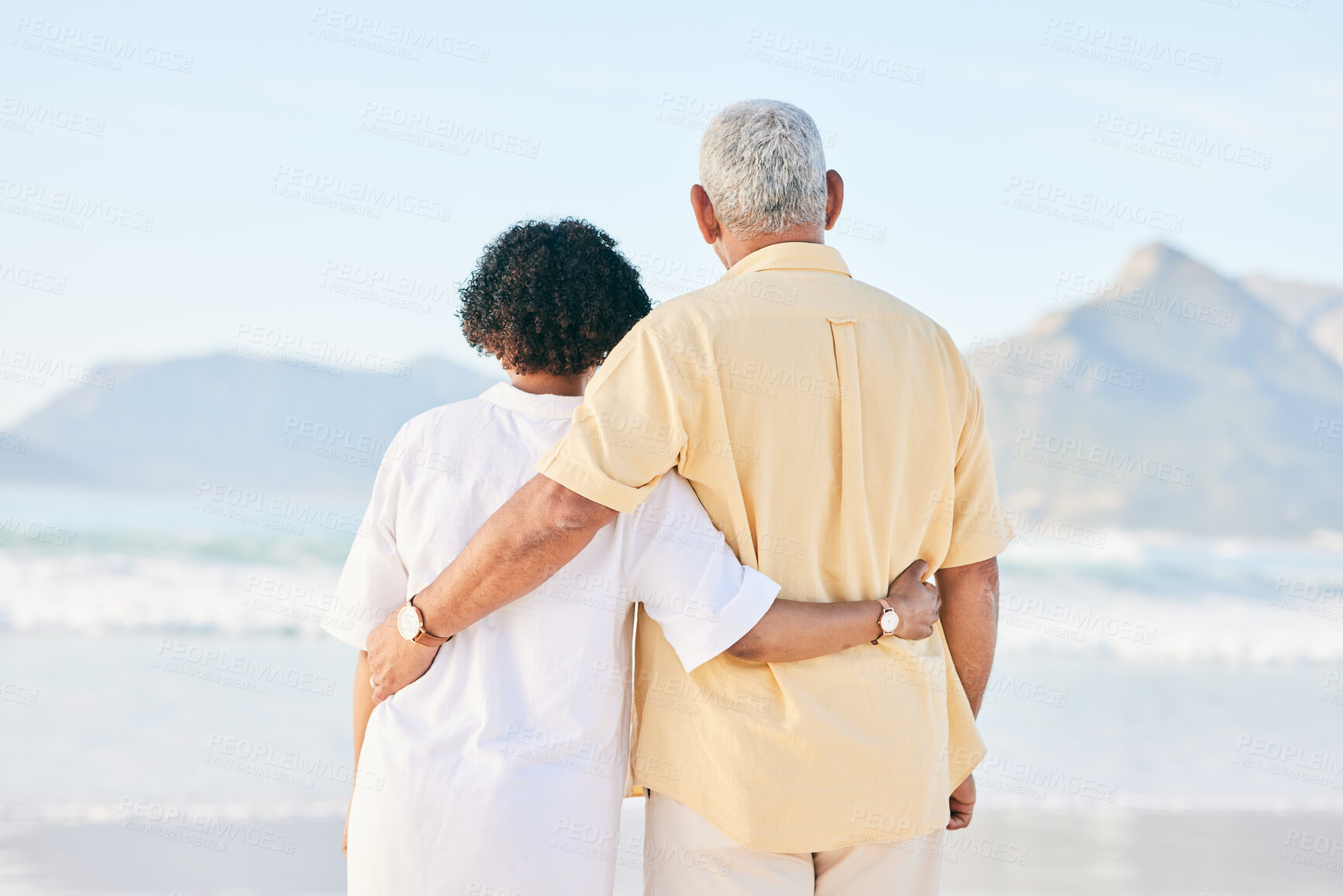 Buy stock photo Senior couple at beach, hug and travel, retirement and love outdoor, vacation with ocean view and relax in nature. Peace, zen and tropical island, man and woman watching sea waves, back and wellness