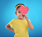 Portrait, heart cut out and girl with smile, joyful and cheerful against blue studio background. Face, female kid and young person with symbol for love, happiness and joyful with development and sign