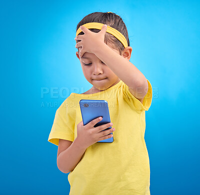 Buy stock photo Phone, face palm and a girl on a blue background in studio reading a text message or post on social media. Contact, mobile and mistake with a young female child looking at bad news on her smartphone