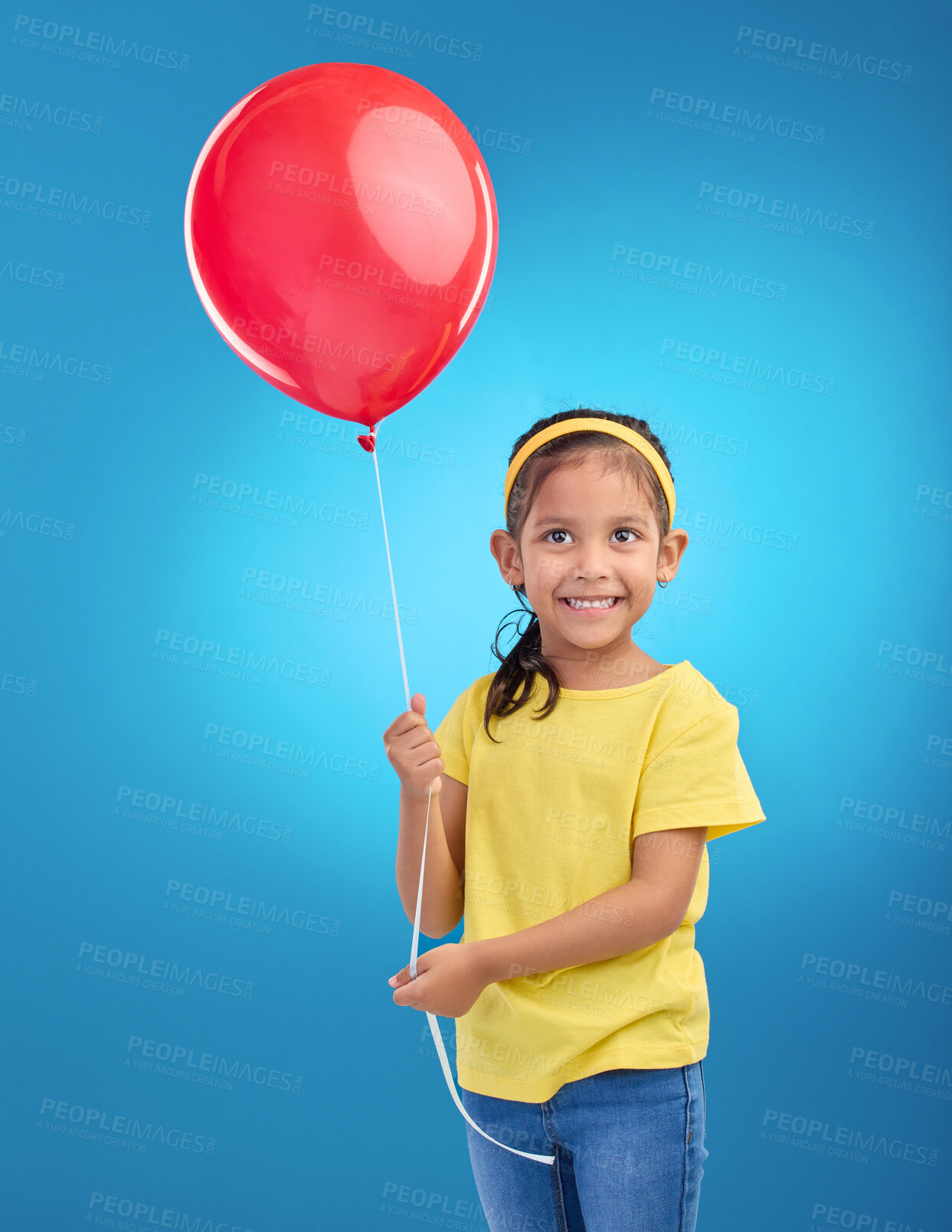 Buy stock photo Happy girl, studio and red balloon of a an excited kid with a smile ready for a birthday party. Celebration, happiness and young child holding balloons in the air with isolated blue background  