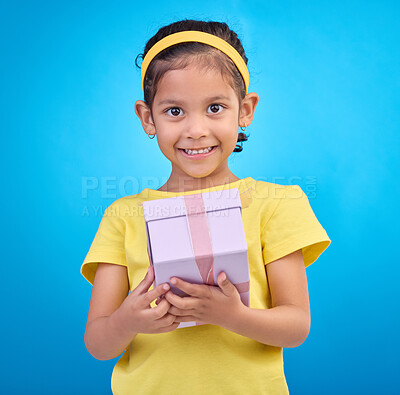 Buy stock photo Gift, box and smile with portrait of girl in studio for celebration, shopping and birthday event. Happiness, surprise and present with child for party, giveaway or product isolated on blue background