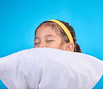 Little girl, pillow and sleep in a studio feeling tired, fatigue and ready for dreaming. Isolated, blue background and happy young child with pillows and closed eyes for sleeping, rest and nap 