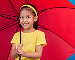 Winter, happy and portrait of a child with an umbrella isolated on a blue background in a studio. Smile, safety and a young girl holding a tool to protect from rain, bad weather and the cold