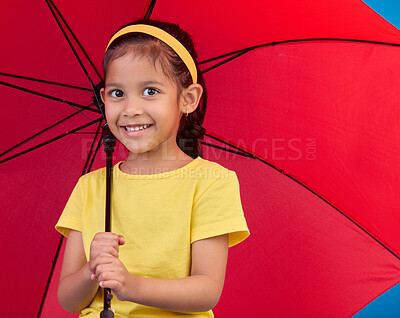 Buy stock photo Winter, happy and portrait of a child with an umbrella, open and red while isolated in a studio. Smile, safety and a young girl protecting from the rain, bad weather and the cold for insurance