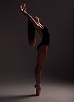 Ballet, woman and artist training, artistic and commitment with girl against a dark studio background. Female performer, artist and ballerina with creativity, happiness and practice for performance