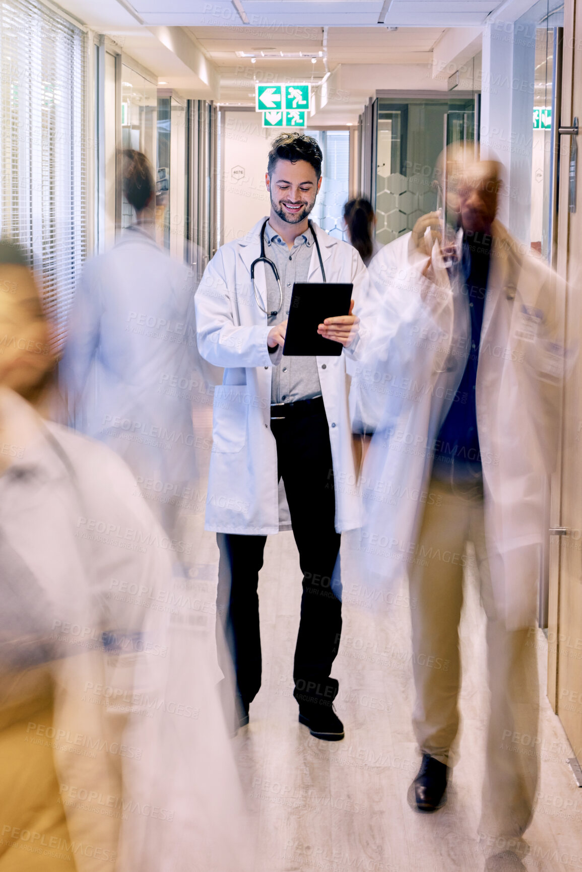 Buy stock photo Digital tablet, happy and man doctor walking in a busy hospital, excited while checking online schedule. Motion blur, male and healthcare expert with app for planning, communication and prescription